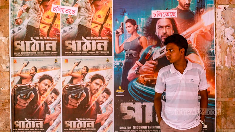 ঢাকার সিনেমা হলে ‘পাঠান’ সিনেমার পোস্টারের সাথে ছবি তুলছেন শাহরুখ ভক্তরা।&amp;nbsp;ছবি: তাওহীদুজ্জামান তপু