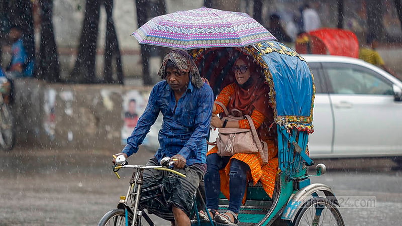 ঢাকা বিশ্ববিদ্যালয়ের টিএসসি এলাকায় গুঁড়িগুঁড়ি বৃষ্টি থেকে নিজেকে ও রিকশাচালককে বাঁচাতে ছাতা হাতে এক নারী।&amp;nbsp;ছবি: মাহমুদ জামান অভি