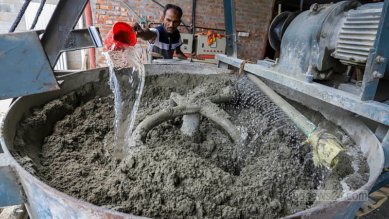 কংক্রিট ব্লক তৈরির জন্য বালি, পাথর ও সিমেন্ট একটি মেশিনের সাহায্যে মেশানো হয়। ছবি: আসিফ মাহমুদ অভি