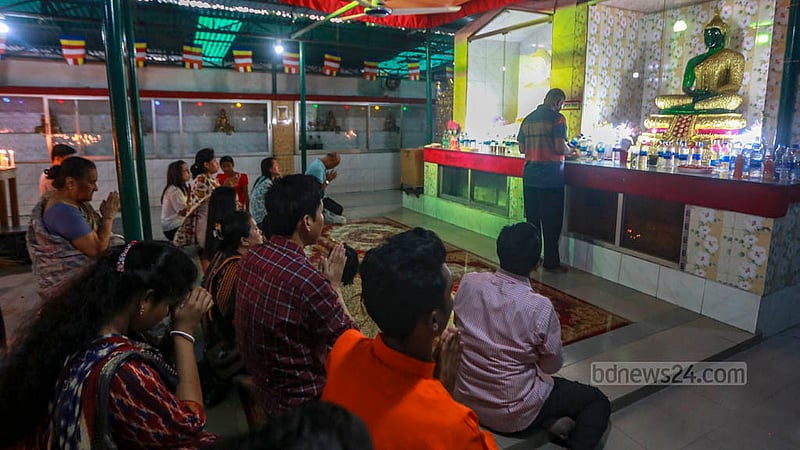 ঢাকার সবুজবাগে ধর্মরাজিক বৌদ্ধ মহাবিহারে বুদ্ধ পূর্ণিমায় বৌদ্ধ মূর্তির সামনে প্রার্থনারত পুণ্যার্থীরা।&amp;nbsp;ছবি: তাওহীদুজ্জামান তপু