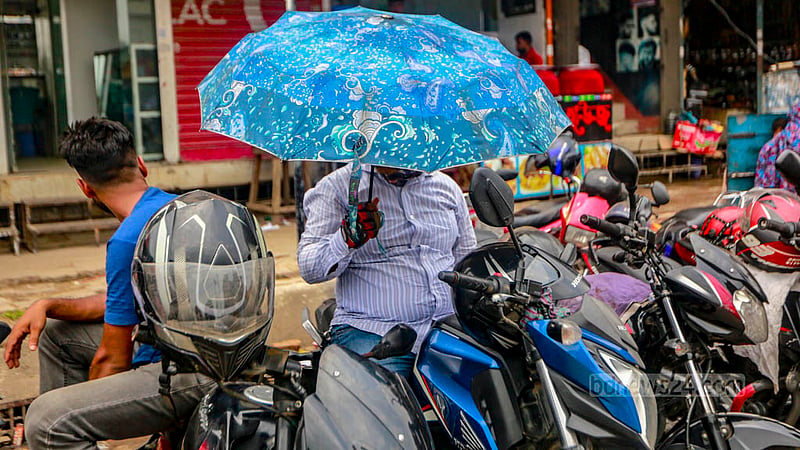 ঢাকার মোহাম্মদপুরের তিনরাস্তা এলাকায় বুধবার দুপুরের রোদে ছাতা মাথায় যাত্রীর অপেক্ষায় একজন বাইকচালক।&amp;nbsp;ছবি: তাওহীদুজ্জামান তপু