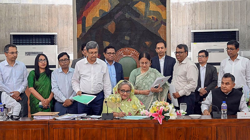 জাতীয় সংসদ ভবনের মন্ত্রিপরিষদ কক্ষে বৃহস্পতিবার মন্ত্রিসভার বিশেষ বৈঠকে ২০২৩-২০২৪ অর্থবছরের বাজেট অনুমোদনের পর তাতে সই করেন প্রধানমন্ত্রী শেখ হাসিনা।&amp;nbsp;ছবি: পিআইডি