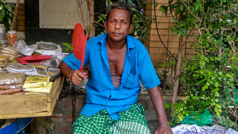 যেমন রোদ তেমন তার তাপ। গরমে তাই হাতপাখাই ভরসা রাস্তার পাশের এই দোকানির।&amp;nbsp;ছবি: তাওহীদুজ্জামান তপু