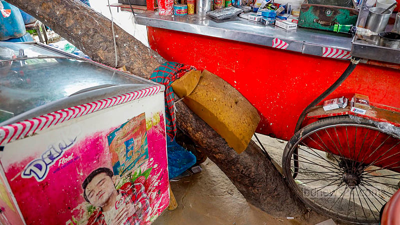 ঢাকার তেজগাঁও শিল্প এলাকার ফুটপাতে একটি গাছকে কেন্দ্র করে গড়ে উঠেছে চায়ের দোকান। গাছের গোড়ার অংশ কংক্রিটে ঢাকা আর গোড়ার ওপরের জায়গায় বসেন দোকানি।&amp;nbsp;ছবি: মাহমুদ জামান অভি