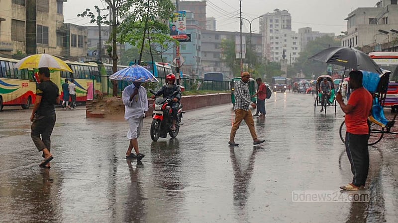 ঢাকার মোহাম্মদপুরে শুক্রবার মুষলধারে বৃষ্টি থেকে রেহাই পেতে অনেককে ছাতা হাতে দেখা যায়।&amp;nbsp;ছবি: তাওহীদুজ্জামান তপু