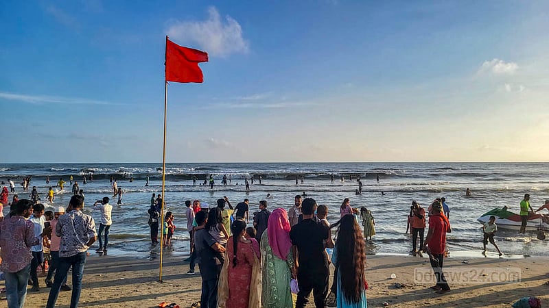 কক্সবাজার সমুদ্র সৈকতে বালু সরে যাওয়ায় বিপজ্জনক হয়ে ওঠা স্থানে পর্যটকদের সতর্ক করতে টাঙানো হয়েছে লাল পতাকা। ছবি:&amp;nbsp;শাফাত রহমান