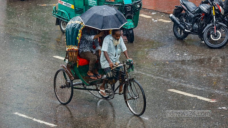 হঠাৎ বৃষ্টিতে রিকশাচালককে বাঁচাতে ছাতা হাতে এক যাত্রী। ছবিটি সোমবার ঢাকার ধানমণ্ডির।&amp;nbsp;ছবি: মাহমুদ জামান অভি