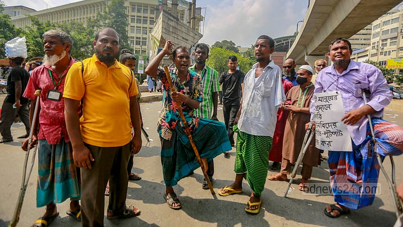 ঢাকার শাহবাগে জাতীয় জাদুঘরের সামনের সড়কে রোববার অবস্থান নেন একদল প্রতিবন্ধী ব্যক্তি।&amp;nbsp;ছবি: তাওহীদুজ্জামান তপু