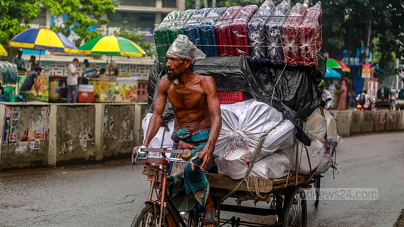 ঢাকা বিশ্ববিদ্যালয়ের টিএসসি এলাকায় বৃহস্পতিবার গুঁড়িগুঁড়ি বৃষ্টির সময়ও গরমের ঘামে ভেজা এই ভ্যান চালক।&amp;nbsp;ছবি: তাওহীদুজ্জামান তপু