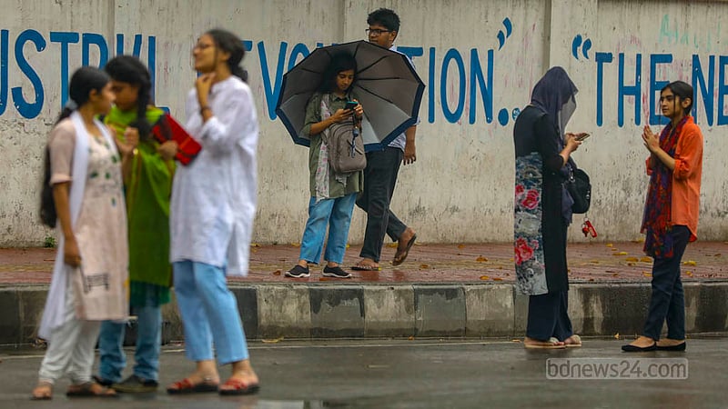 ঢাকা বিশ্ববিদ্যালয়ে বৃহস্পতিবার দুপুরে গুঁড়িগুঁড়ি বৃষ্টির মধ্যে বাসের অপেক্ষায় শিক্ষার্থীরা।&amp;nbsp;ছবি: তাওহীদুজ্জামান তপু