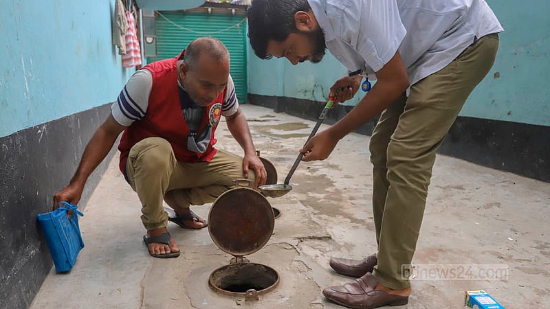 মিরপুরের মাজার রোডে বাড়ির পানির মিটারের স্থানে জমে থাকা পানিতে ডেঙ্গুর বাহক এইডিস মশার লার্ভা আছে কি না তা দেখছেন ডিএনসিসির এক কর্মী। ছবি: আসিফ মাহমুদ অভি