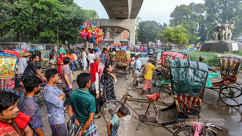 শুক্রবার বিকেলে আষাঢ়ের বৃষ্টি নামলে ঢাকার টিএসসি এলাকায় ঘুরতে আসা মানুষ, পথচারী ও রিকশা চালকেরা আশ্রয় নেন মেট্রোরেলের লাইনের নিচে। ছবি: আসিফ মাহমুদ অভি