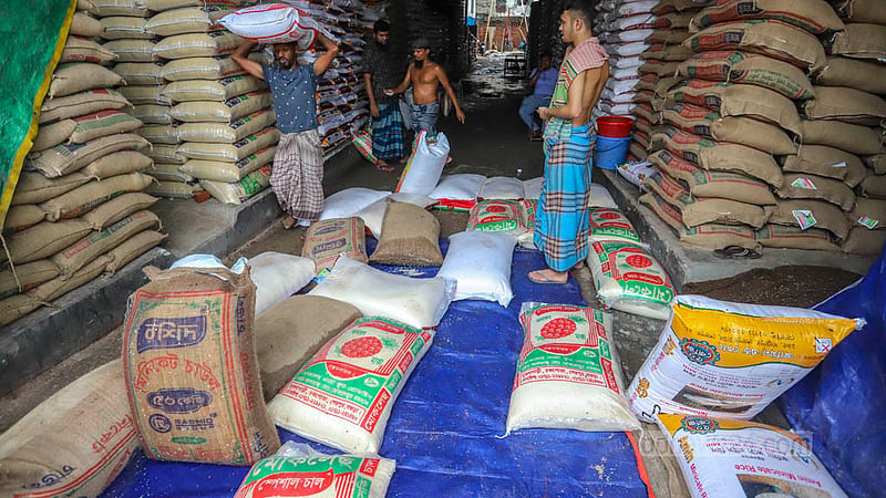 মোহাম্মদপুর কৃষি মার্কেটে বৃষ্টির পানি ঢুকে ভিজে যাওয়া চাল কম দামে বিক্রি করা হচ্ছে। ছবি: আসিফ মাহমুদ অভি