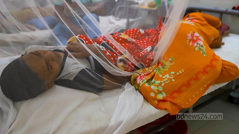 ঢাকার সোহরাওয়ার্দী মেডিকেল কলেজ হাসপাতালে ডেঙ্গু আক্রান্ত সন্তানের পায়ের কাছে ঘুময়ে আছেন এক নারী।&amp;nbsp;ছবি: তাওহীদুজ্জামান তপু