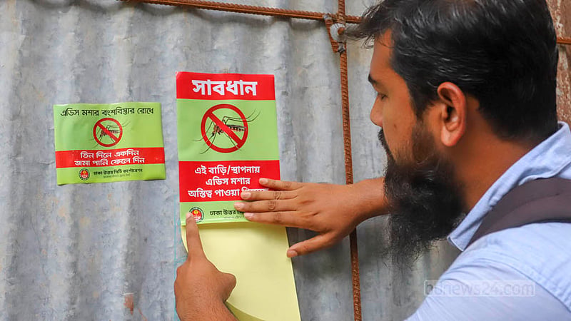 মিরপুর মাজার রোড এলাকায় রোববার নির্মাণাধীন একটি ভবনে জমে থাকা পানিতে এইডিস মশার লার্ভা পাওয়ায় সতর্কতামূলক স্টিকার লাগানো হচ্ছে। ছবি: আসিফ মাহমুদ অভি