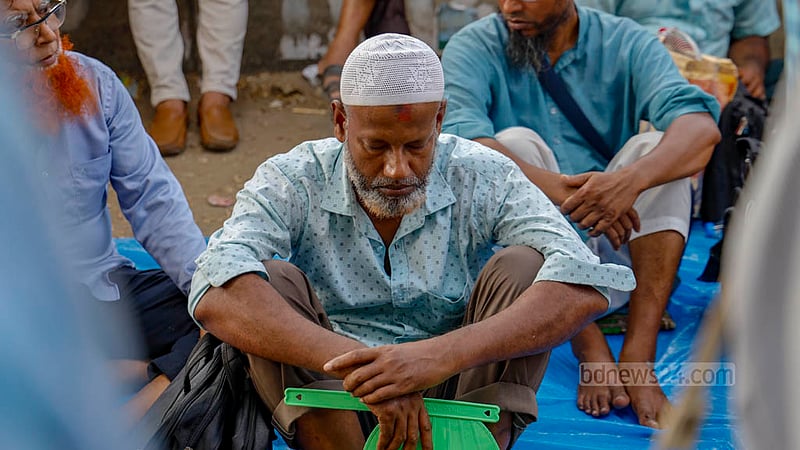 জাতীয় প্রেস ক্লাবের সামনে মাধ্যমিক শিক্ষা প্রতিষ্ঠান জাতীয়করণের দাবিতে মঙ্গলবার থেকে এই সড়কে অবস্থান করেছেন শিক্ষকরা। খোলা আকাশের নিচে রোদের মধ্যে বসে থাকতে থাকতে অনেককেই দেখাচ্ছে ক্লান্ত।&amp;nbsp;ছবি: মাহমুদ জামান অভি
