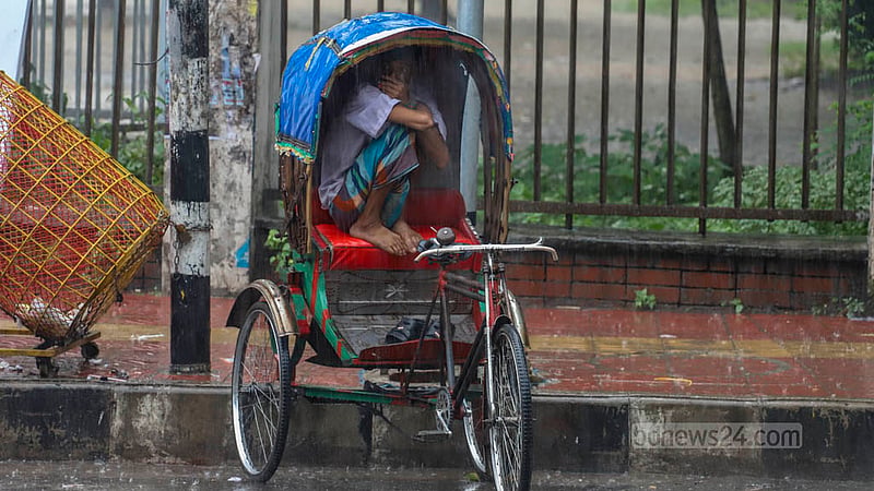 আষাঢ়ের শেষ দিন শুক্রবার বিকেলে নামা বৃষ্টি থেকে নিজেকে রক্ষায় সিটের উপর বসে পড়েন এক রিকশা চালক। ছবি: আসিফ মাহমুদ অভি