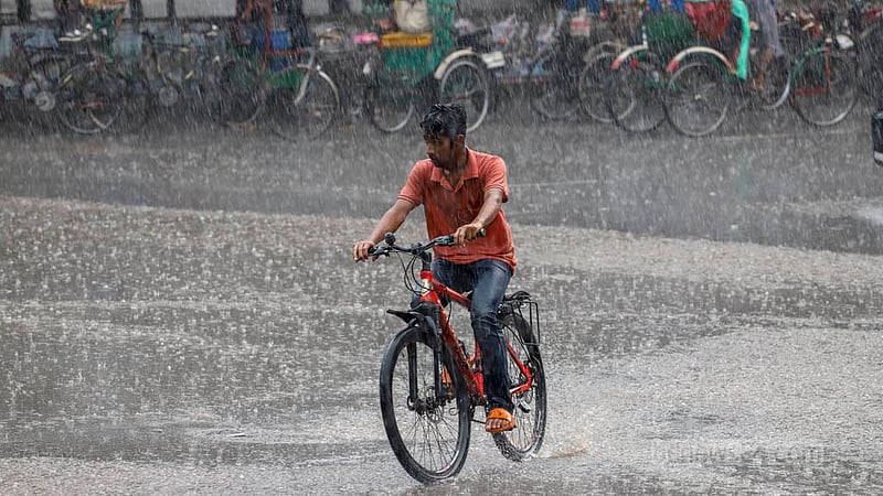 আষাঢ়ের বৃষ্টিতে ভিজে শুক্রবার ঢাকার টিএসসি এলাকায় সাইকেল চালিয়ে যাচ্ছেন এক তরুণ। ছবি: আসিফ মাহমুদ অভি