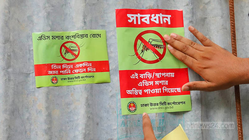 মিরপুর মাজার রোড এলাকায় রোববার নির্মাণাধীন একটি ভবনে জমে থাকা পানিতে এইডিস মশার লার্ভা পাওয়ায় সতর্কতামূলক স্টিকার লাগানো হচ্ছে। ছবি: আসিফ মাহমুদ অভি