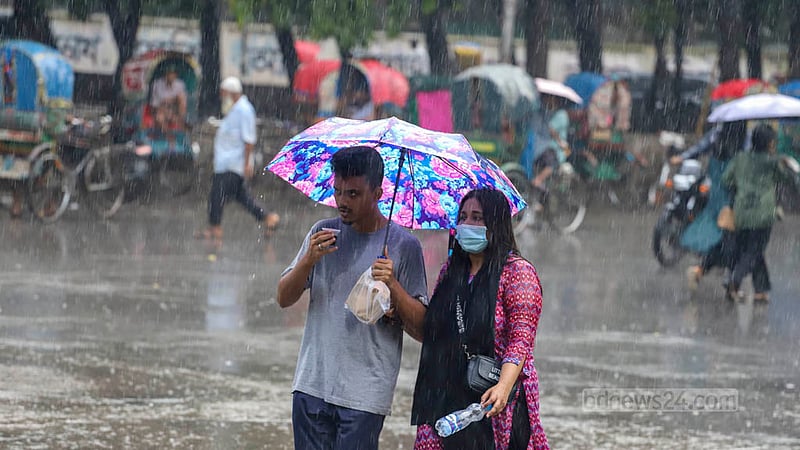 ঢাকার টিএসসি এলাকায় শুক্রবার বিকেলে আষাঢ়ের বৃষ্টিতে ছাতা মাথায় এক জুটি। ছবি: আসিফ মাহমুদ অভি