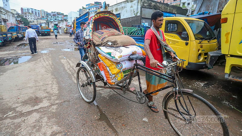 অল্প ভেজা চাল শুকানোর জন্য রিকশায় করে নিয়ে যাওয়া হচ্ছে অন্যখানে। ছবি: আসিফ মাহমুদ অভি