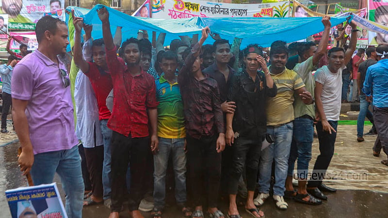 ঢাকার নয়া পল্টনে শুক্রবার দুপুরে বিএনপির সমাবেশে বৃষ্টির মধ্যে পলিথিন মাথায় নেতাকর্মীরা।&amp;nbsp;ছবি: তাওহীদুজ্জামান তপু