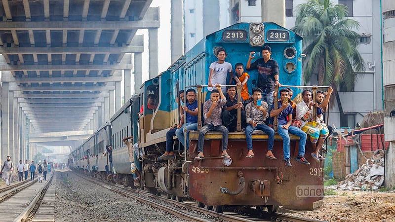 ঢাকার কমলাপুর রেলস্টেশন থেকে ছেড়ে আসা ট্রেনটির ইঞ্জিনের সামনে বসে আছে একদল তরুণ, তাদের মধ্যে অনেকেই করছে ভিডিও। এমন ঝুঁকিপূর্ণ ভ্রমণ হর হামেশায় করে থাকে অনেকেই।&amp;nbsp;ছবি: মাহমুদ জামান অভি