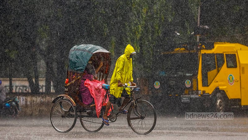 ঢাকা বিশ্ববিদ্যালয়ের টিএসসিতে শুক্রবার দুপুরে বৃষ্টির মধ্যে রেইনকোট পরে রিকশা চালাচ্ছেন চালক, পেছনে মোবাইল ফোনে ছবি তোলায় ব্যস্ত যাত্রী।&amp;nbsp;ছবি: মাহমুদ জামান অভি
