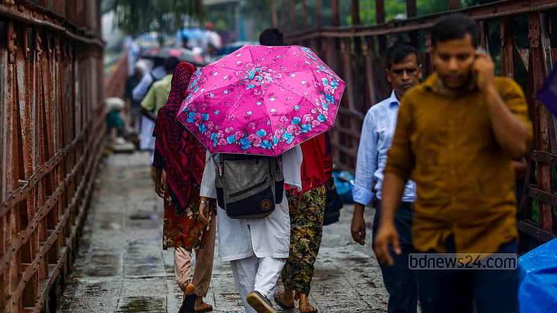 কমলাপুর ফুটব্রিজে বুধবার ঝুম বৃষ্টির মধ্যে বাড়ি ফেরার পথে ফুলছাপা ছাতা হাতে এক শিক্ষার্থী।&amp;nbsp;ছবি: মাহমুদ জামান অভি