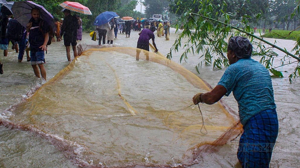চট্টগ্রাম-কক্সবাজার মহাসড়কের চন্দনাইশের সড়কে পাশে পানি বেড়ে যাওয়ায় স্থানীয়রা জাল দিয়ে মাছ ধরছেন।