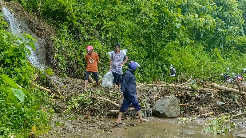 বান্দরবান-রুমা সড়কে যে অংশে পাহাড় ধস হয়েছে, সেইটুকু হেঁটে পার হচ্ছেন স্থানীয়রা।&amp;nbsp;