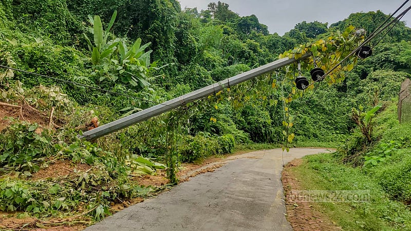 বান্দরবন শহর থেকে পাঁচ কিলোমিটর দূরে মিলনছড়ি এলাকায় পাহাড় ধসে সড়কে পড়ে রয়েছে বিদ্যুতের খুঁটি।