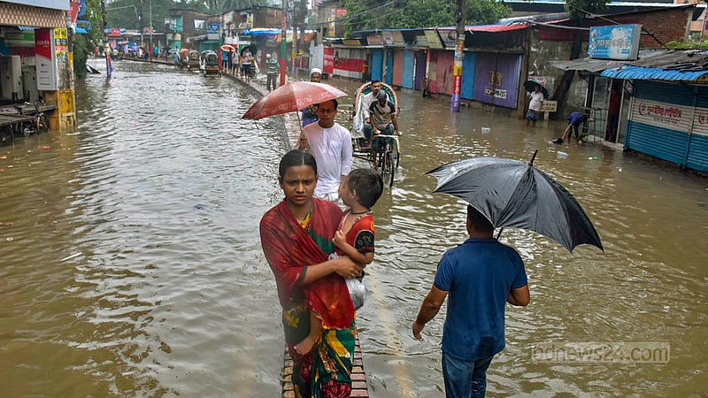 রাতভর বৃষ্টিতে হাঁটু পানির নিচে চট্টগ্রামের চকবাজার কাপাসগোলা এলাকার সড়ক। শুক্রবার সকালে পানি ভেঙ্গে যাতায়াত করতে গিয়ে বিপত্তিতে পড়েন মানুষকে।&amp;nbsp;ছবি: সুমন বাবু