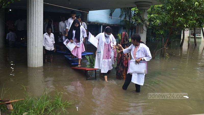 চট্টগ্রামের চকবাজার এলাকায় বৃষ্টির পানিতে জলাবদ্ধতার কারণে কাপাসগোলা সিটি করপোরেশন মহিলা কলেজ থেকে পরীক্ষা শেষে টেবিলের উপর দিয়ে বেরিয়ে আসছেন এইচএসসি পরীক্ষার্থীরা।&amp;nbsp;&amp;nbsp;ছবি: সুমন বাবু