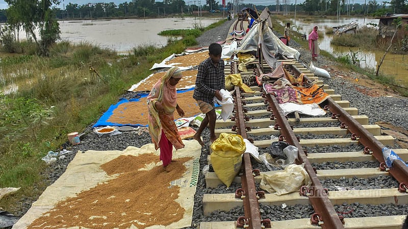 ভারি বৃষ্টি ও পাহাড়ি ঢলের কারণে চট্টগ্রামের সাতকানিয়ার কেঁওচিয়া ইউনিয়ন এলাকায় বসতবাড়ি পানিতে তলিয়ে যাওয়ায় ক্ষতি হয়েছে গোলার ধানেরও। দোহাজারী-সাতকানিয়া রেল লাইনের পাশে বন্যার পানিতে সেই ধান শুকাচ্ছে কয়েকটি পরিবার।&amp;nbsp;ছবি: সুমন বাবু