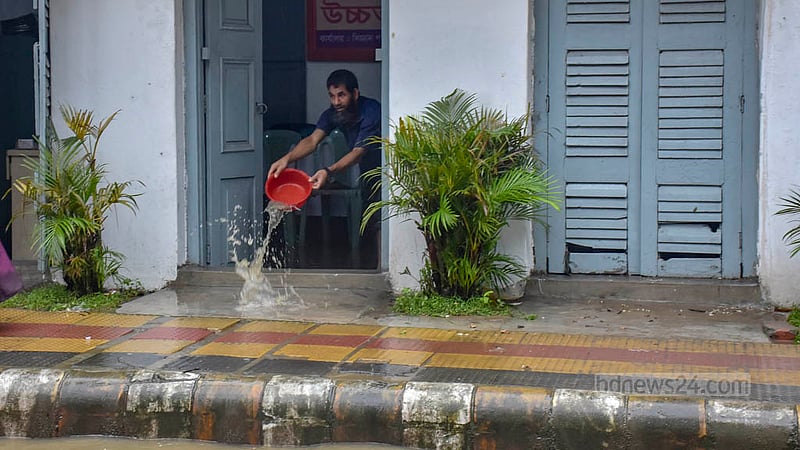 রাতভর বৃষ্টি ও জোয়ারে চট্টগ্রামের চকবাজার এলাকার ওষুধের এই দোকানে পানি ঢুকে পড়ে। শুক্রবার সকালে সেই পানি বের করছেন দোকানি।&amp;nbsp;ছবি: সুমন বাবু