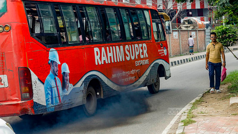 ঢাকার হাতিরঝিলে কালো ধোঁয়া ছাড়ছে একটি বাস, পাশ দিয়েই হেঁটে যাচ্ছিলেন একজন।&amp;nbsp;ছবি: মাহমুদ জামান অভি