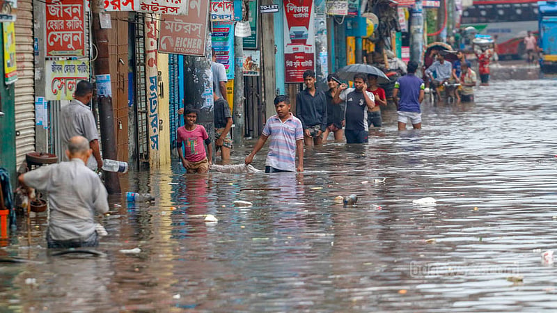 ঢাকার সায়েদাবাদ এলাকায় শুক্রবার দুপুরের কয়েক ঘণ্টার বৃষ্টিতে কোমর সমান পানি মধ্যে দিয়ে যাতায়াত করছে মানুষ।