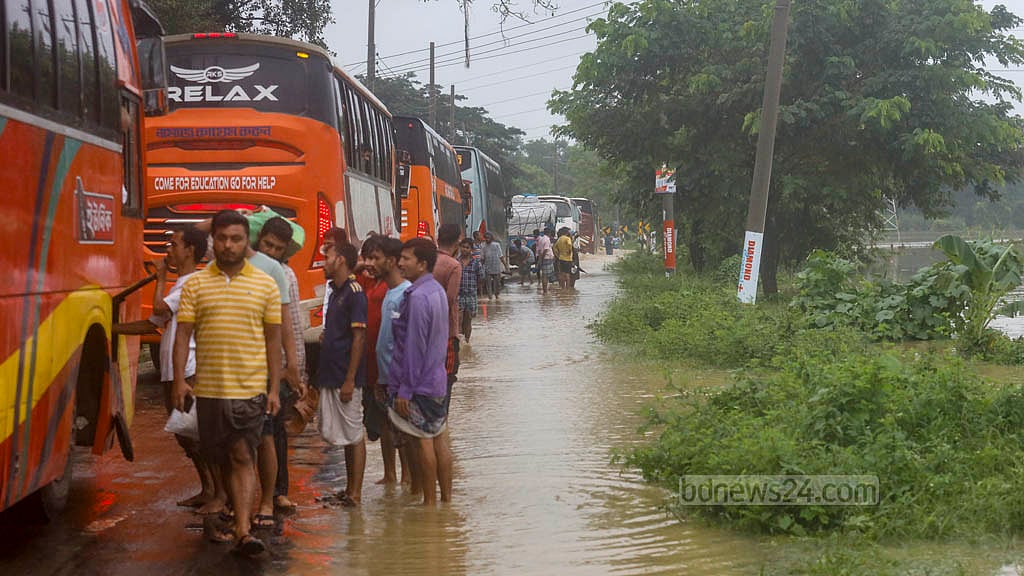 চট্টগ্রাম-কক্সবাজার মহাসড়কের চন্দনাইশের হাশিমপুর এলাকায় সোমবার সকালে পানিবন্দি হয়ে সড়কের উপর দাঁড়িয়ে আছে বাস।&nbsp;ছবি: মাহমুদ জামান অভি