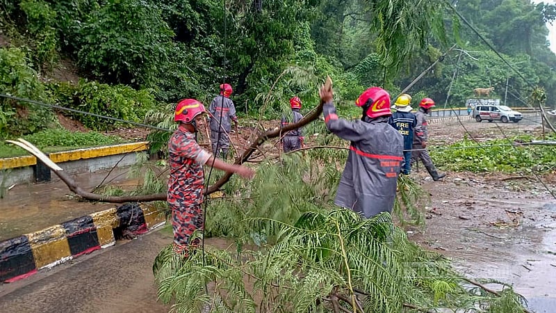 পাহাড় ধসে বন্ধ হয়ে গেছে চট্টগ্রাম লালখান বাজার টাইগারপাস সড়ক। শুক্রবার সকালে গাছ ও মাটি সরানোর কাজ শুরু করেন ফায়ার সার্ভিস কর্মীরা।&amp;nbsp;ছবি: সুমন বাবু