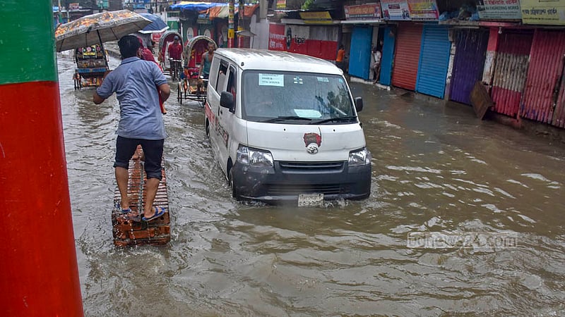 রাতভর বৃষ্টিতে হাঁটু পানির নিচে চট্টগ্রামের চকবাজার কাপাসগোলা এলাকার সড়ক। শুক্রবার সকালে পানি ভেঙ্গে যাতায়াত করতে গিয়ে বিপত্তিতে পড়েন মানুষকে।&amp;nbsp;ছবি: সুমন বাবু