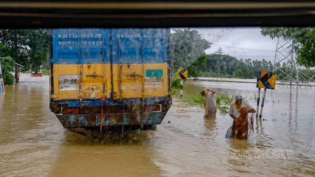 চট্টগ্রাম-কক্সবাজার মহাসড়কের চন্দনাইশের হাশিমপুর এলাকায় সড়কে হাঁটুর উপরে পানি, তার মধ্যে জাল দিয়ে মাছ ধরছেন স্থানীয়রা।&nbsp;ছবি: মাহমুদ জামান অভি