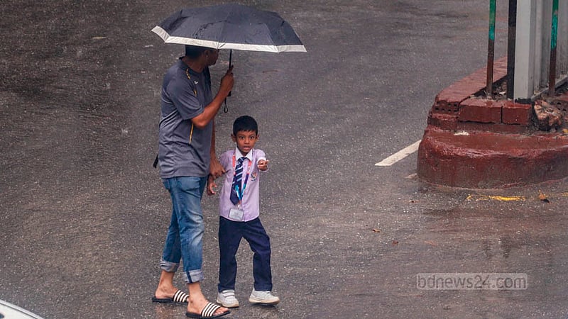 ঢাকার ধানমন্ডি এলাকায় বুধবার দুপুরের বৃষ্টিতে ছাতা হাতে পথচারীরা।&amp;nbsp;ছবি: তাওহীদুজ্জামান তপু