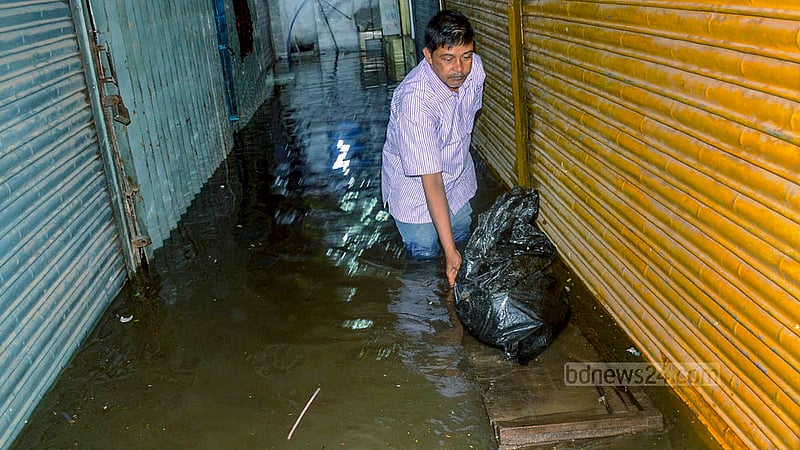 বৃষ্টি ও জোয়ারের পানির কারণে চট্টগ্রামের চকবাজার এলাকায় জলাবদ্ধতার সৃষ্টি হলে রাস্তার পাশে ছোট ছোট মার্কেটের দোকানগুলোতে পানি ঢুকে পড়ে।&amp;nbsp;ছবি: সুমন বাবু