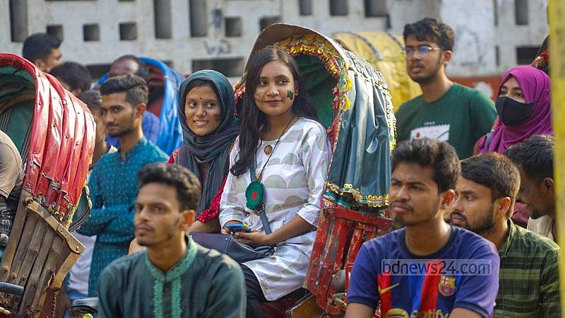 ঢাকা বিশ্ববিদ্যালয়ের টিএসসি প্রাঙ্গণে শনিবার দুপুর থেকে রিকশার উপরে বসে বাংলাদেশ দলের খেলা দেখছেন দুই তরুণী।