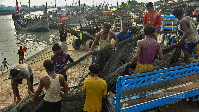 সাগরে ২২ দিনের জন্য মাছ ধরা বন্ধ হয়ে যাওয়ায় চট্টগ্রাম ফিসারিঘাটে নৌকা থেকে জাল নামিয়ে আনছেন জেলেরা।&amp;nbsp;ছবি: সুমন বাবু