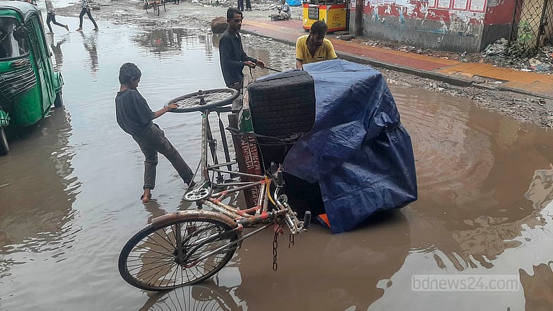 ঢাকায় টানা বৃষ্টিতে শুক্রবার মালিবাগ এলাকায় জলাবদ্ধতার সৃষ্টি হয়, জমে থাকা পানিতে মালামালসহ একটি ভ্যান উল্টে যায়।