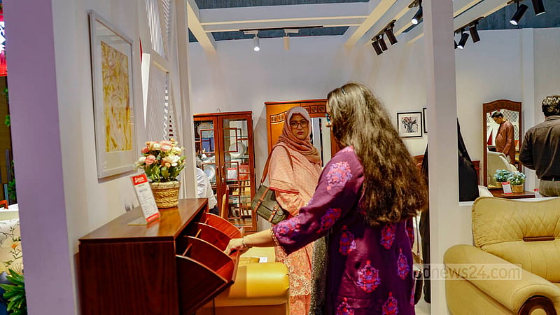 ঢাকায় জাতীয় ফার্নিচার মেলায় শুক্রবার একটি স্টলে আসবাবপত্র দেখছেন দুই নারী।&amp;nbsp;ছবি: মাহমুদ জামান অভি