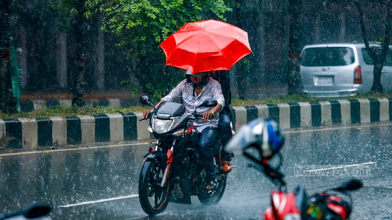 ঢাকার শহীদ ক্যাপ্টেন এম মনসুর আলী এভিনিউতে সোমবার দুপুরে বৃষ্টির মধ্যে ছাতা হাতে মোটর সাইকেলের যাত্রী।&amp;nbsp;ছবি: মাহমুদ জামান অভি