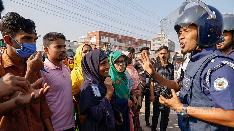 বেতন বৃদ্ধির দাবিতে মঙ্গলবার সকোলে গাজীপুর চৌরাস্তা এলাকায় বিক্ষোভরত পোশাক শ্রমিকদের থামানোর চেষ্টায় পুলিশ সদস্যরা।&amp;nbsp; ছবি: মাহমুদ জামান অভি